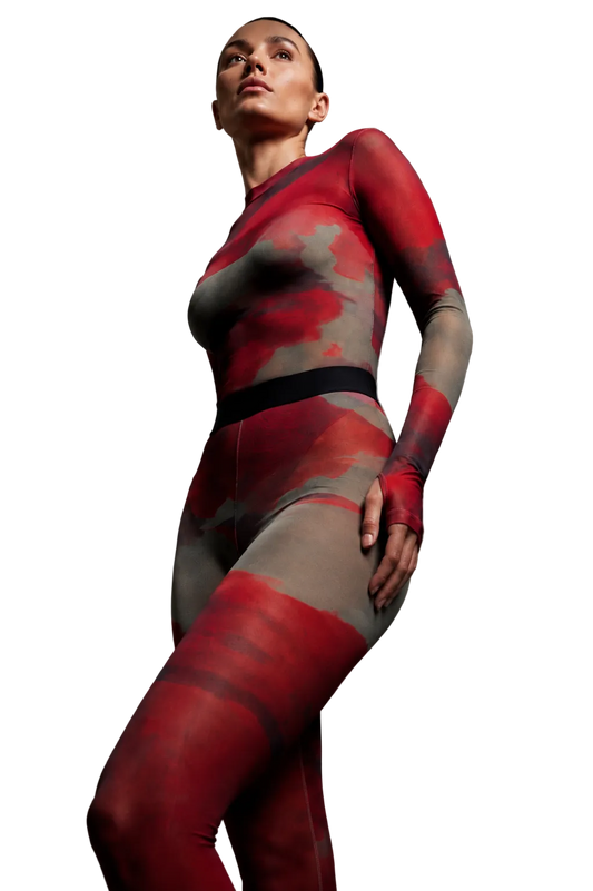 Low-angle studio shot of a model highlighting the mock-neck silhouette and liquid mineral energy print of the Superior Agate Secondskin mesh two-piece set.