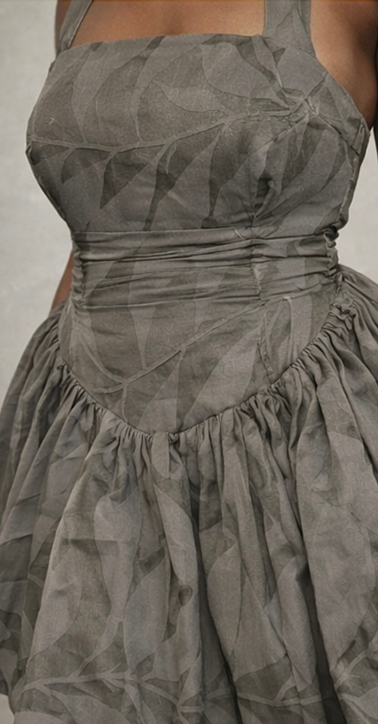 Grey patterned dress with a fitted bodice and flowing skirt.
